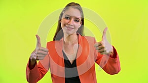 Woman showing double thumbs up, like gesture. Yellow space studio