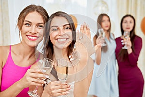 Woman showing engagement ring to camera.