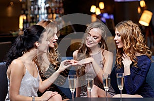 Woman showing engagement ring to her friends photo