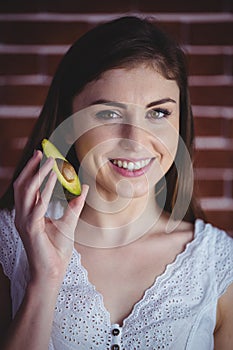 Woman showing fresh avocado