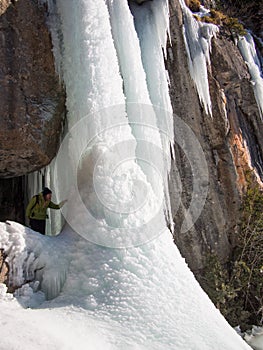 Woman showing a frozen waterfall