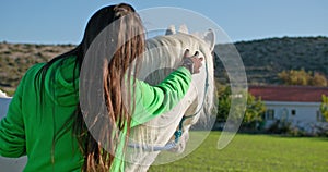 Woman showing genuine care and devotion to her horse in a picturesque ranch