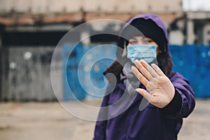 Woman showing gesture stop. Woman wears protective mask against infectious diseases and flu. Health care concept. Coronavirus