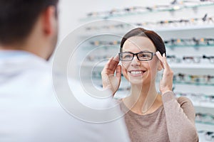 Woman showing glasses to optician at optics store