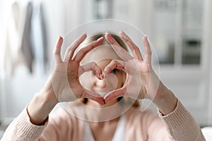 Woman showing heart shape gesture, selective focus on hands