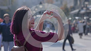 woman showing heart shape by hands. A cute Asian girl spends the summer on vacation in Europe. The girl is happy and