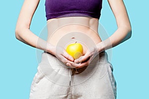 Woman showing her abs with apple after weight loss