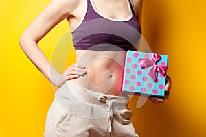 Woman showing her abs with gift box