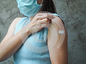 Woman showing her arm with bandage after receiving vaccine. immunization, inoculation and Coronavirus  Covid-19  pandemic.