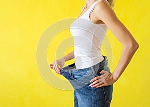 Woman showing her big trousers after successful diet and weight loss