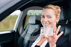 Woman showing her driving license out of car