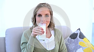 Woman showing her glass of milk to the camera