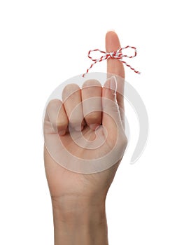 Woman showing index finger with tied bow as reminder on white background, closeup