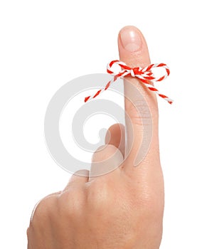 Woman showing index finger with tied bow as reminder on white background, closeup