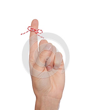 Woman showing index finger with tied bow as reminder on white background, closeup