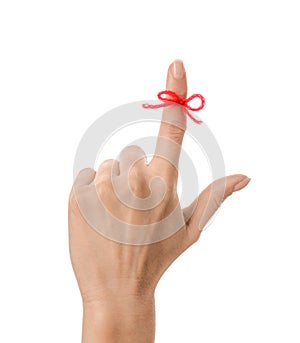 Woman showing index finger with tied red bow as reminder on white background, closeup