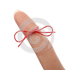 Woman showing index finger with tied red bow as reminder on white background, closeup