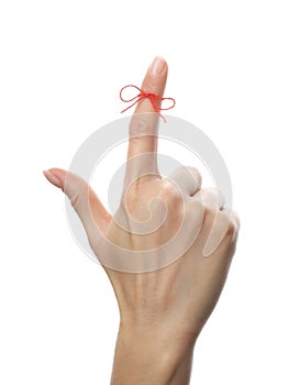 Woman showing index finger with tied red bow as reminder on white background, closeup