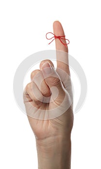 Woman showing index finger with tied red bow as reminder on white background, closeup