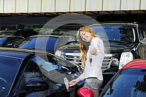 Woman showing key of new sports car