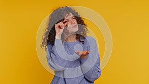 Woman showing a little bit gesture with sceptic smile, showing minimum sign, measuring small size