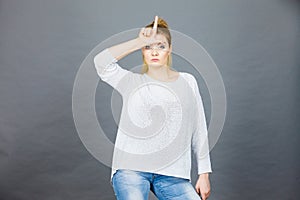 Woman showing loser gesture with L on forehead