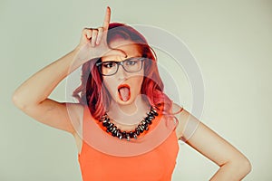 Woman showing loser sign wears glasses photo