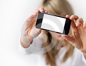Woman showing mobile phone with empty display