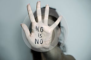 Woman showing a note with the text no is no