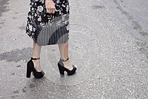 A woman showing off her high heels and Handbag photo