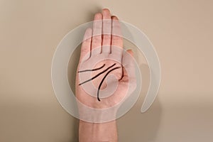 Woman showing palm with drawn lines on color background. Chiromancy and foretelling photo