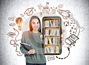 Woman showing phone with books on shelf, education sketch on grey wall