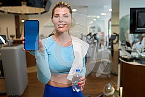 Woman showing pre keyed smartphone with gym discount card