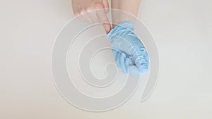 Woman showing proper technique of removing used protective medical gloves