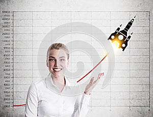 Woman is showing a rocket sketch and a graph