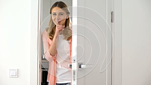 Woman showing silence gesture, closing door, hotel client asking not disturb photo