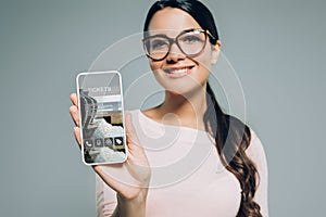 woman showing smartphone with app for tickets