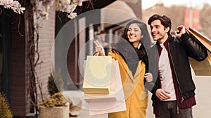 Woman showing something in store window to her husband