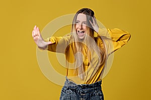 woman showing stop gesture on yellow background