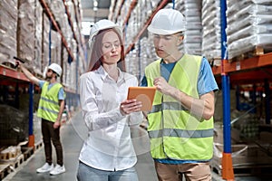 Woman showing tablet to worker and colleague behind