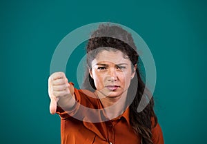 Woman showing thumb down sign gesture in studio