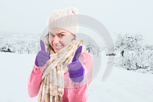 Woman showing thumbs up as like gesture in winter