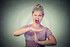 Woman showing time out hand gesture frustrated screaming to stop