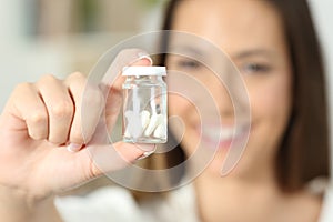 Woman showing a transparent bottle of pills