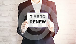 Woman showing white card with TIME TO RENEW word . Business