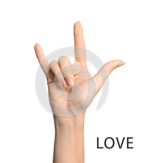 Woman showing word Love on background, closeup. American sign language