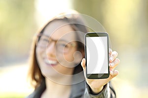 Woman showing you a smart phone screen outdoor