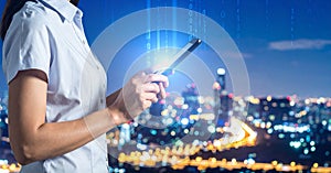 Multiple exposure of female programmer with tablet, digital binary code and night city.