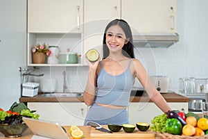 A woman shows an avocado to the camera while she prepares her healthy meals in the kitchen