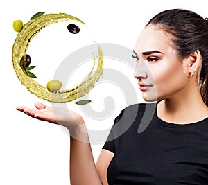 Woman shows circulate splash of olive oil with olives in hand.